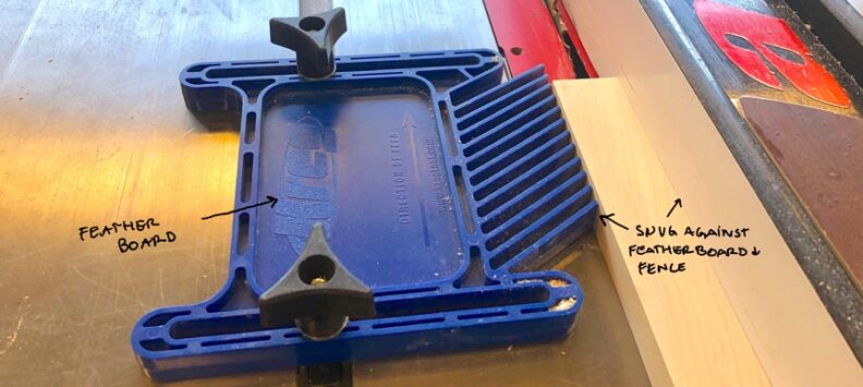 The feather board rests on the table saw to the left of the material to be cut. The material should rest snug between the feather board and the fence. Image links to larger version.