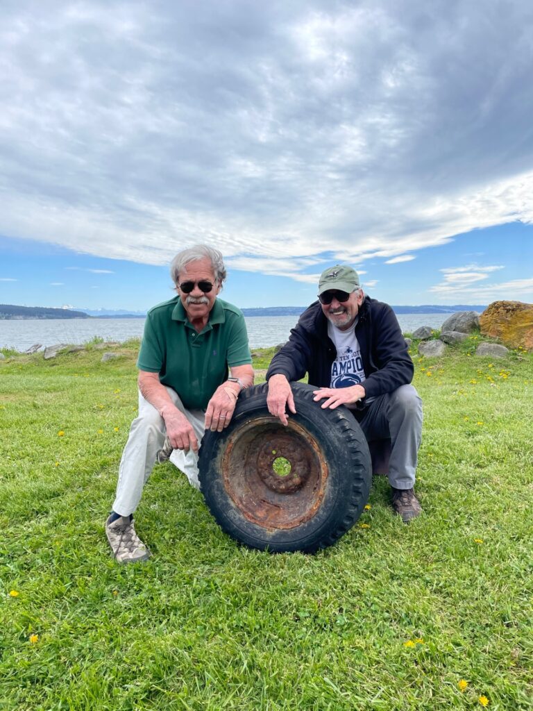 Image showing two volunteers kneeling next to a tire 