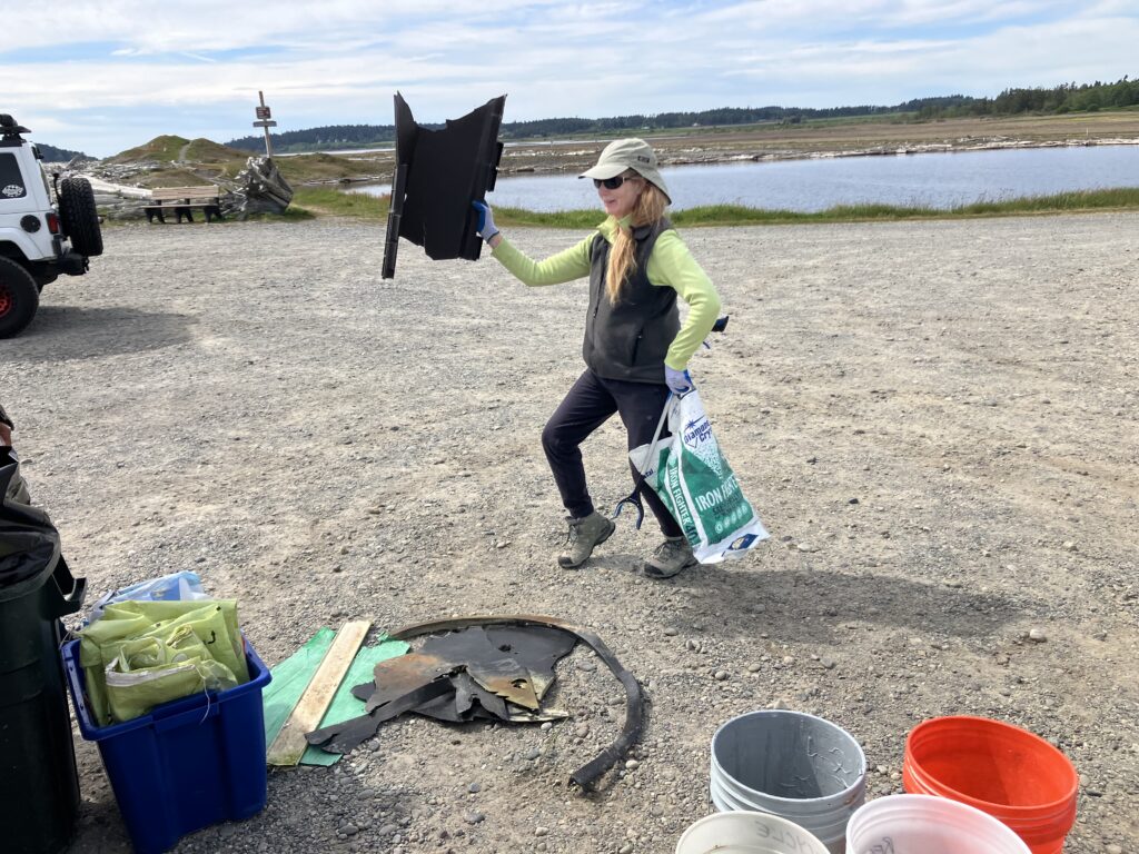 Image of volunteer holding plastic pieces of garbage.