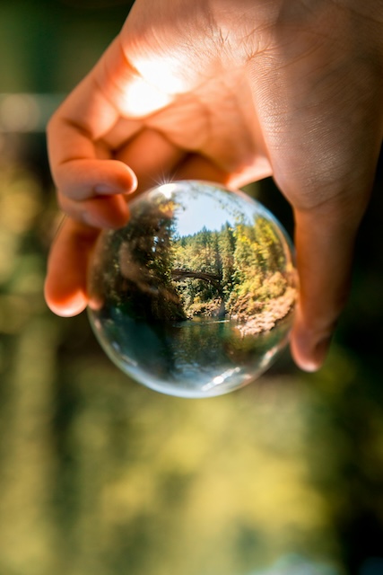 Hand holding glass ball reflecting Washington bridge