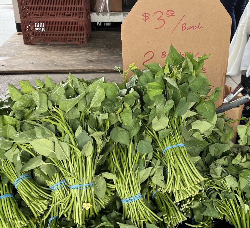 bunches of sweetpotato greens for sale in a market