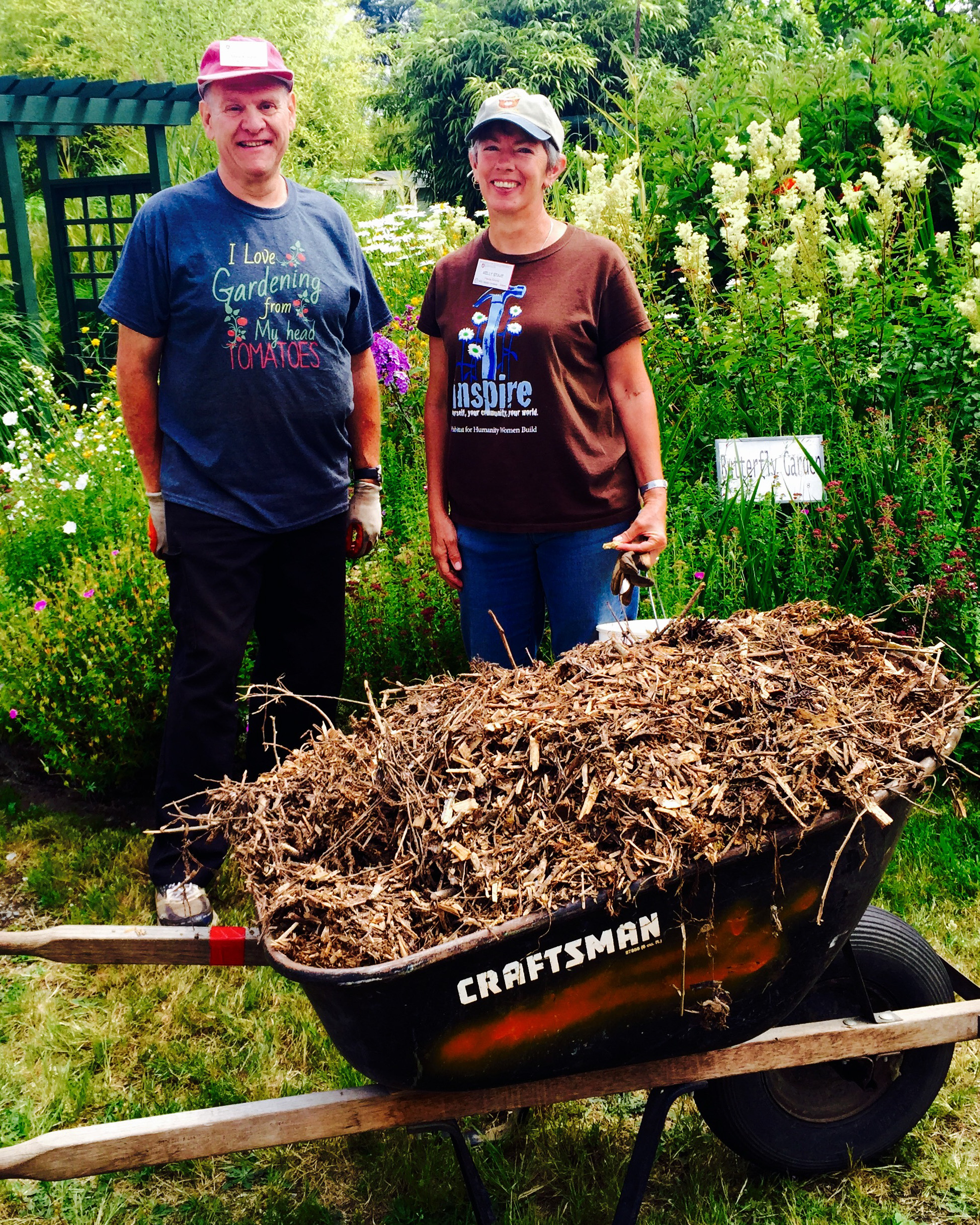 Two master gardeners moving compost.