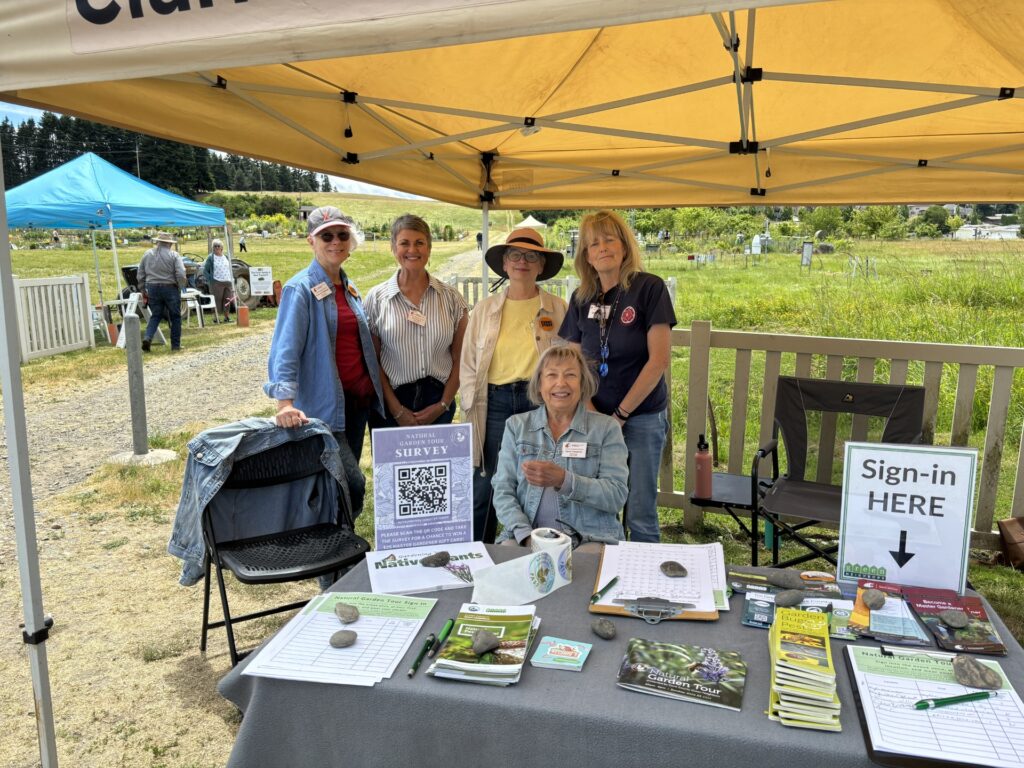 Master gardeners greeting guests at an event.