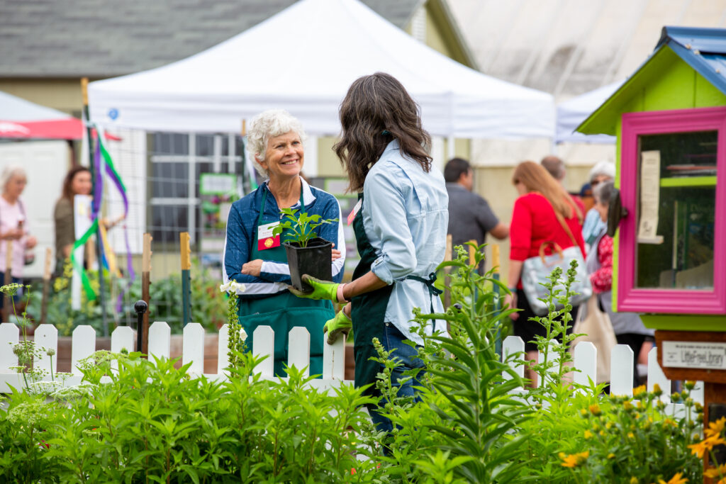 Two women talking at a garden event.