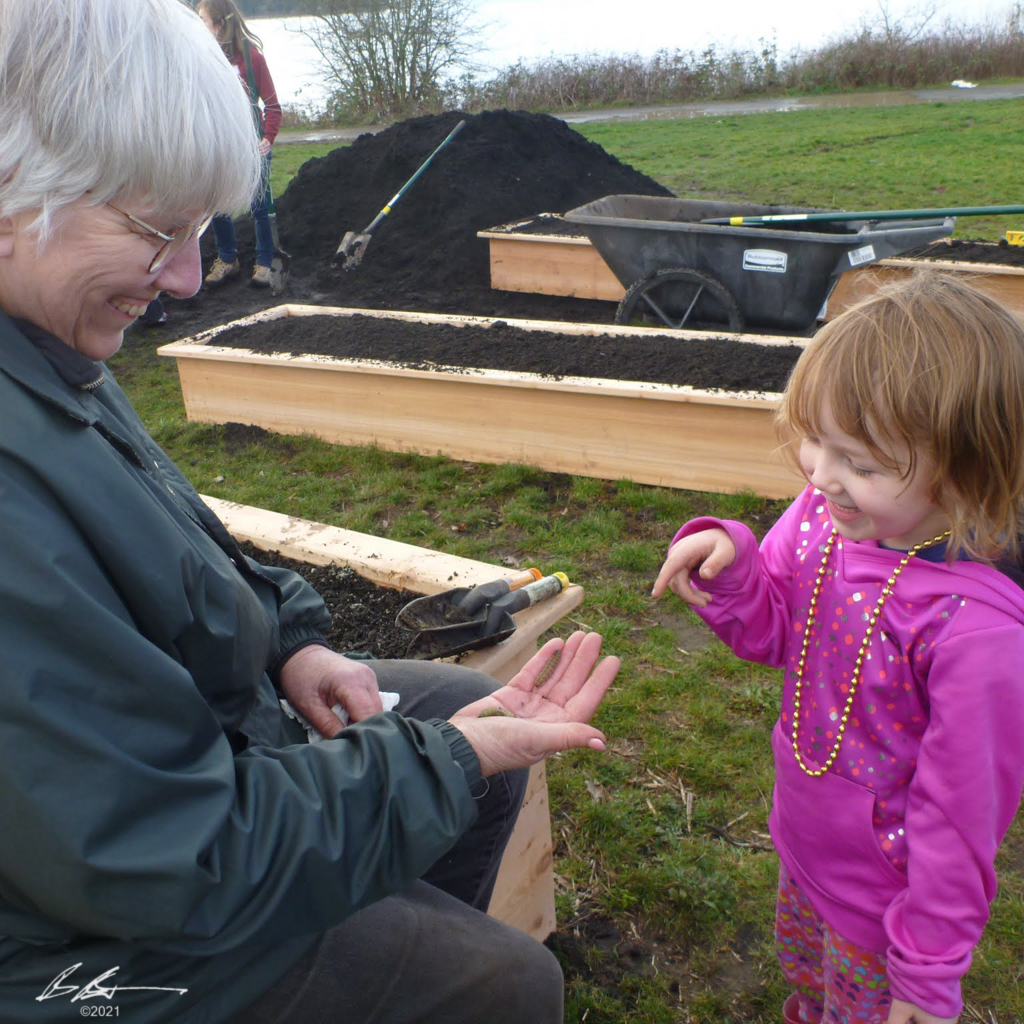 Sharon Collman is showing a child a caterpillar.