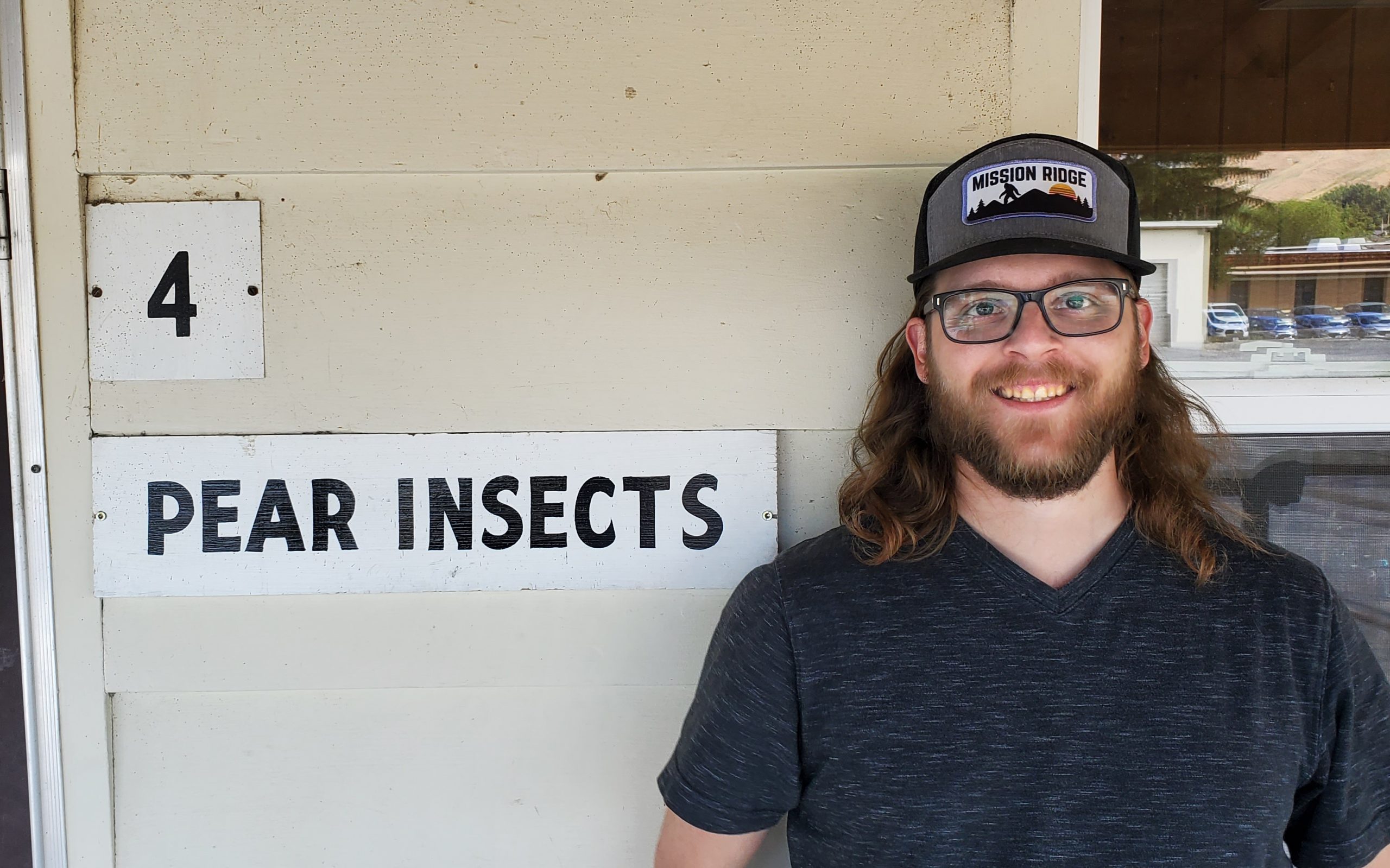Cody Andre next to "pear insects" sign