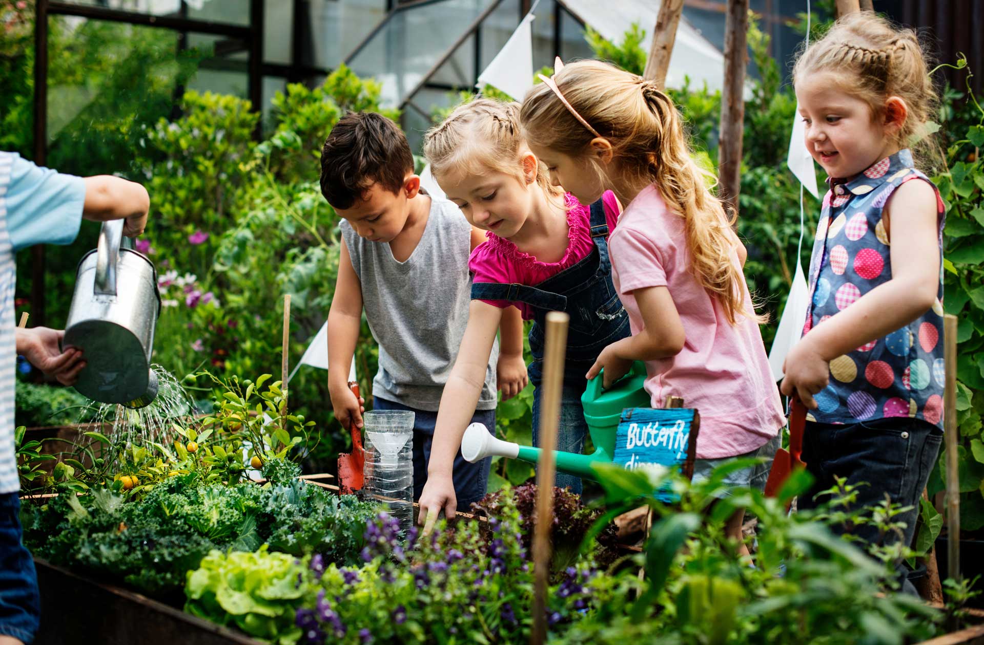 Kids gardening in green house.