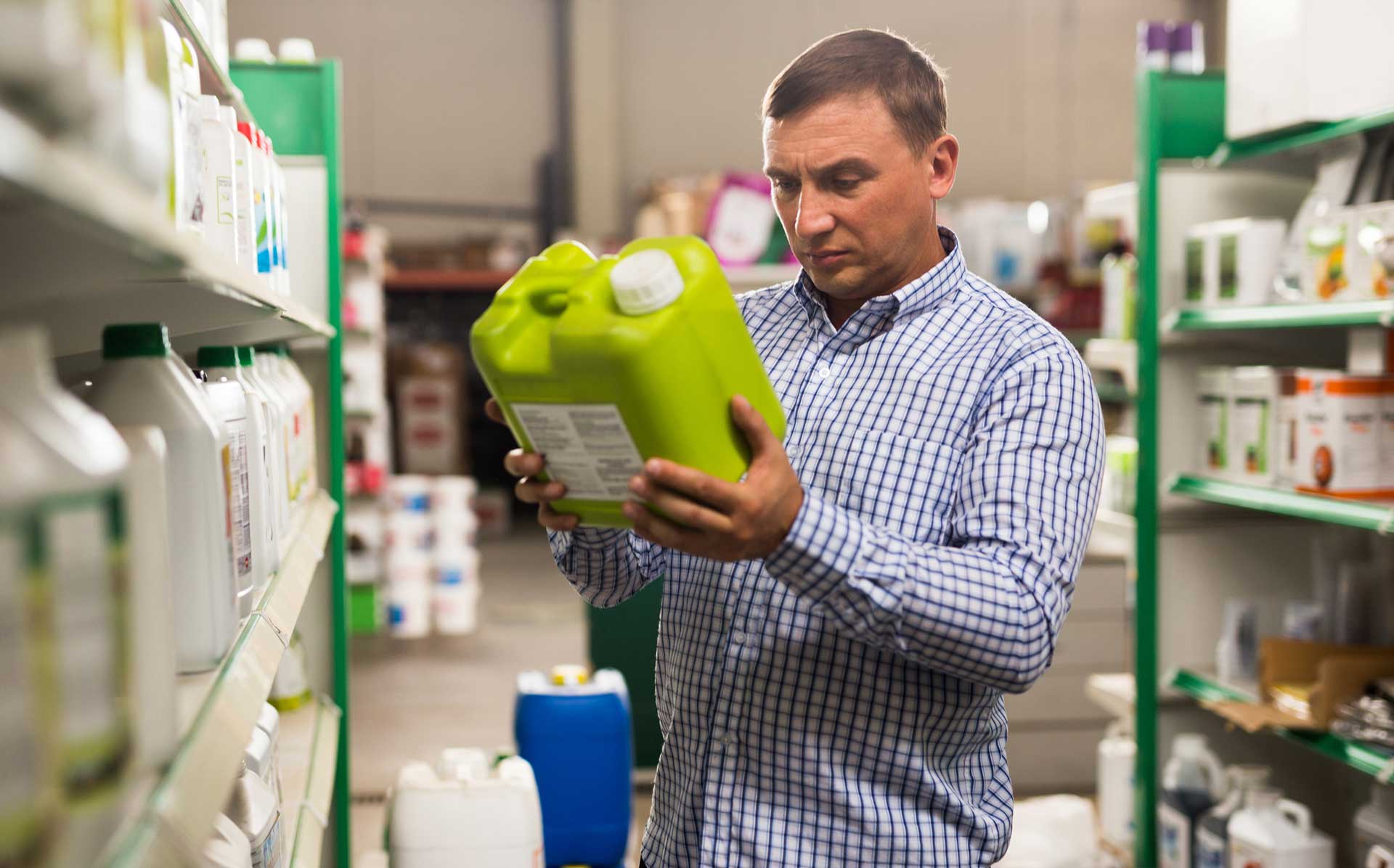 Man reading label of pesticide container.