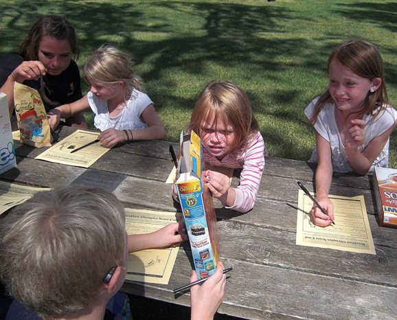 Children working on crafts at a picnic table