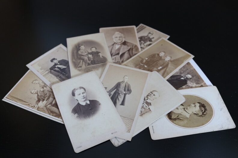 A fan-shaped pile of antique black and white photographs