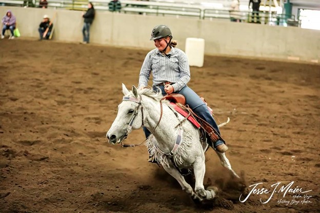 A youth on a horse riding in a show ring