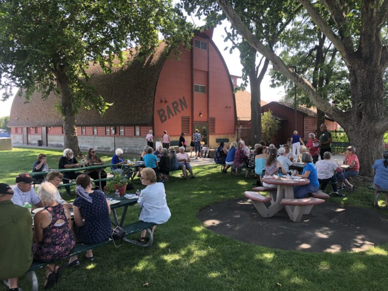 Large group of master gardeners enjoying a picnic outside the Red Barn at Ahtanum Park.