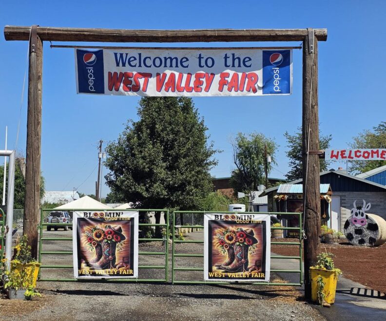 Front gates to the West Valley Fair with a banner stating "Welcome to the West Valley Fair" and images of their fair theme "Bloomin Good Time"  