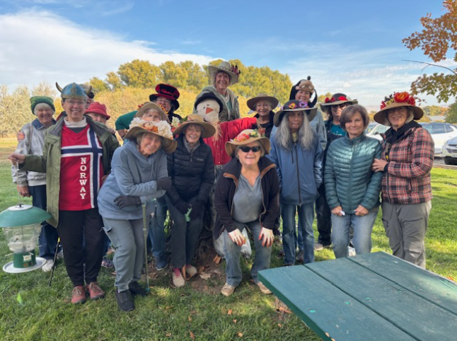 A group of senior master gardeners, all wearing fun-loving hats.