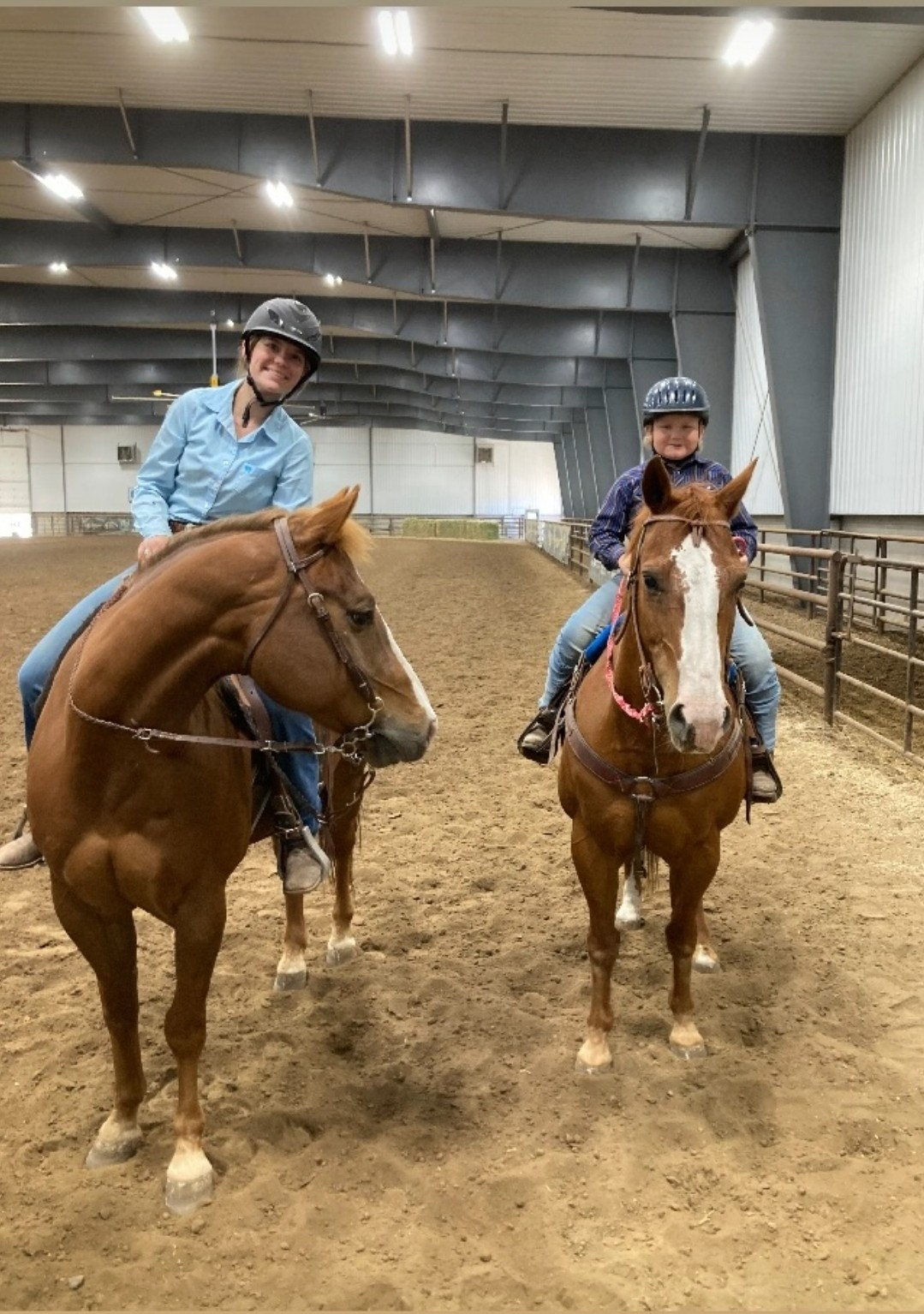Two youth members smiling white on their horse 