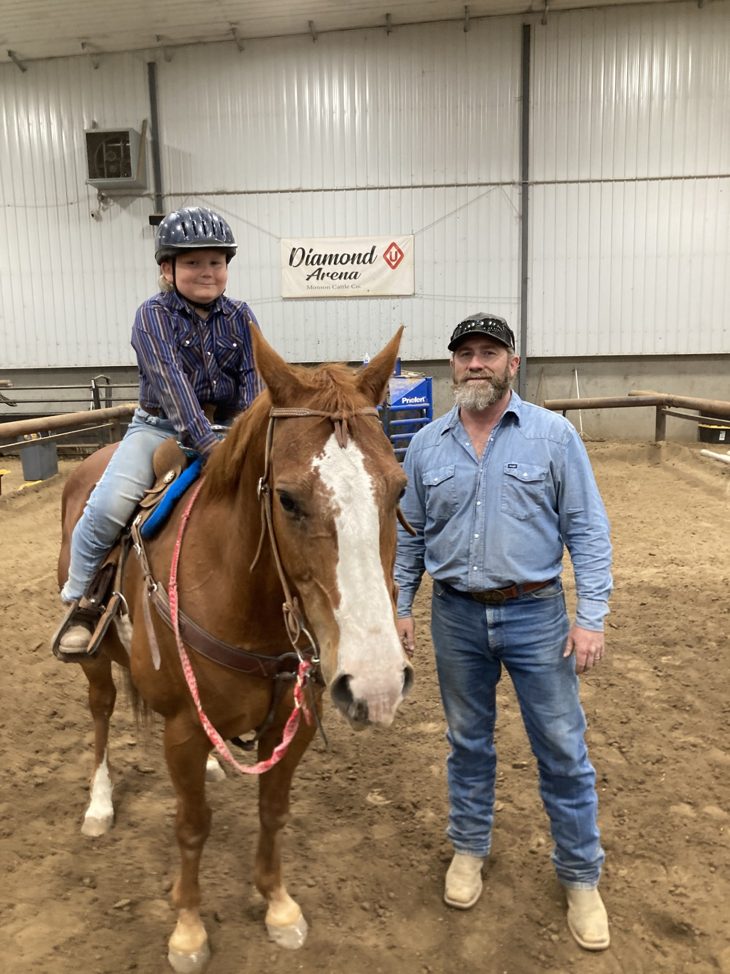 Young youth member on his horse smiling in a photo next to his Dad 