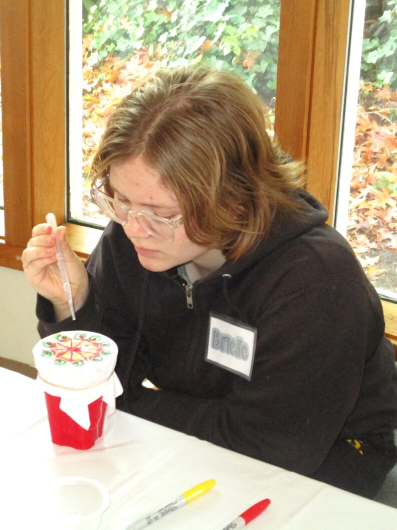 A youth member doing her project for the sharpie tie dye workshop.
