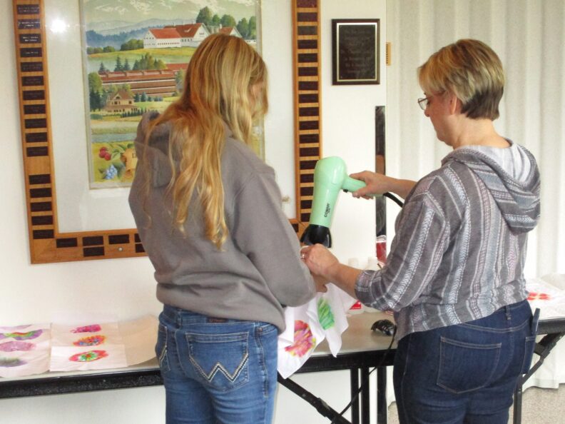 A youth member and workshop instructor working on sharpie tie dyes