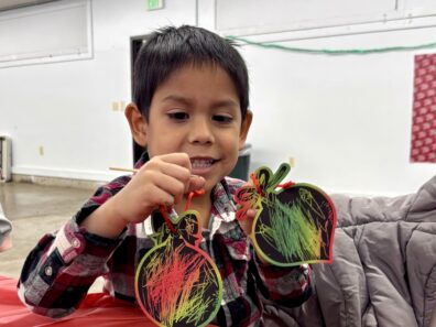 Youth member scratched off paper ornaments and they turned colorful.