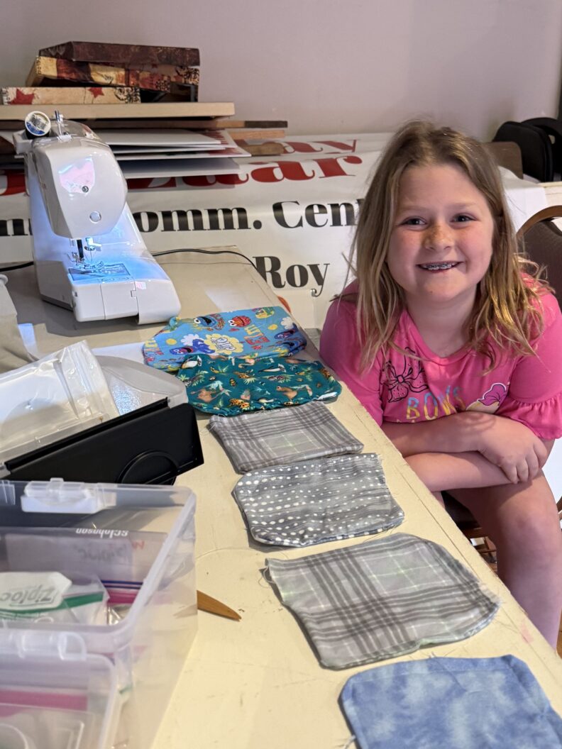 Youth member showing what she has sewn for a service project