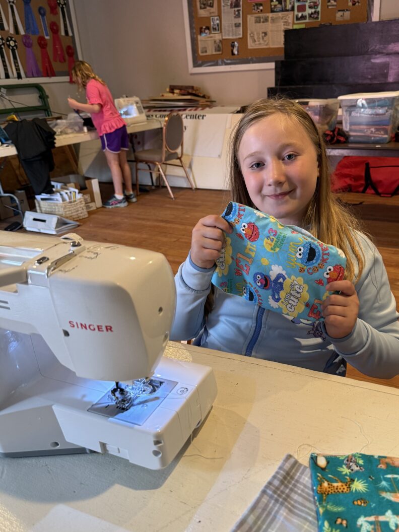 Youth member showing what she has sewn for a service project