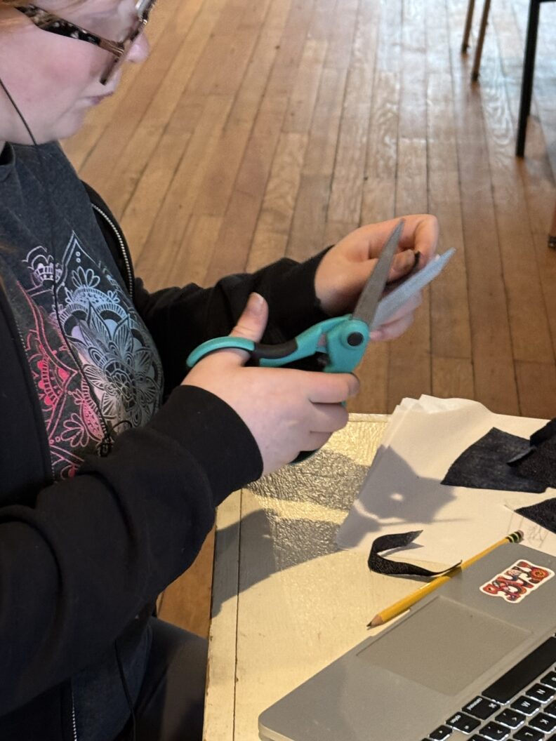 Youth member cutting out fabric for a service project