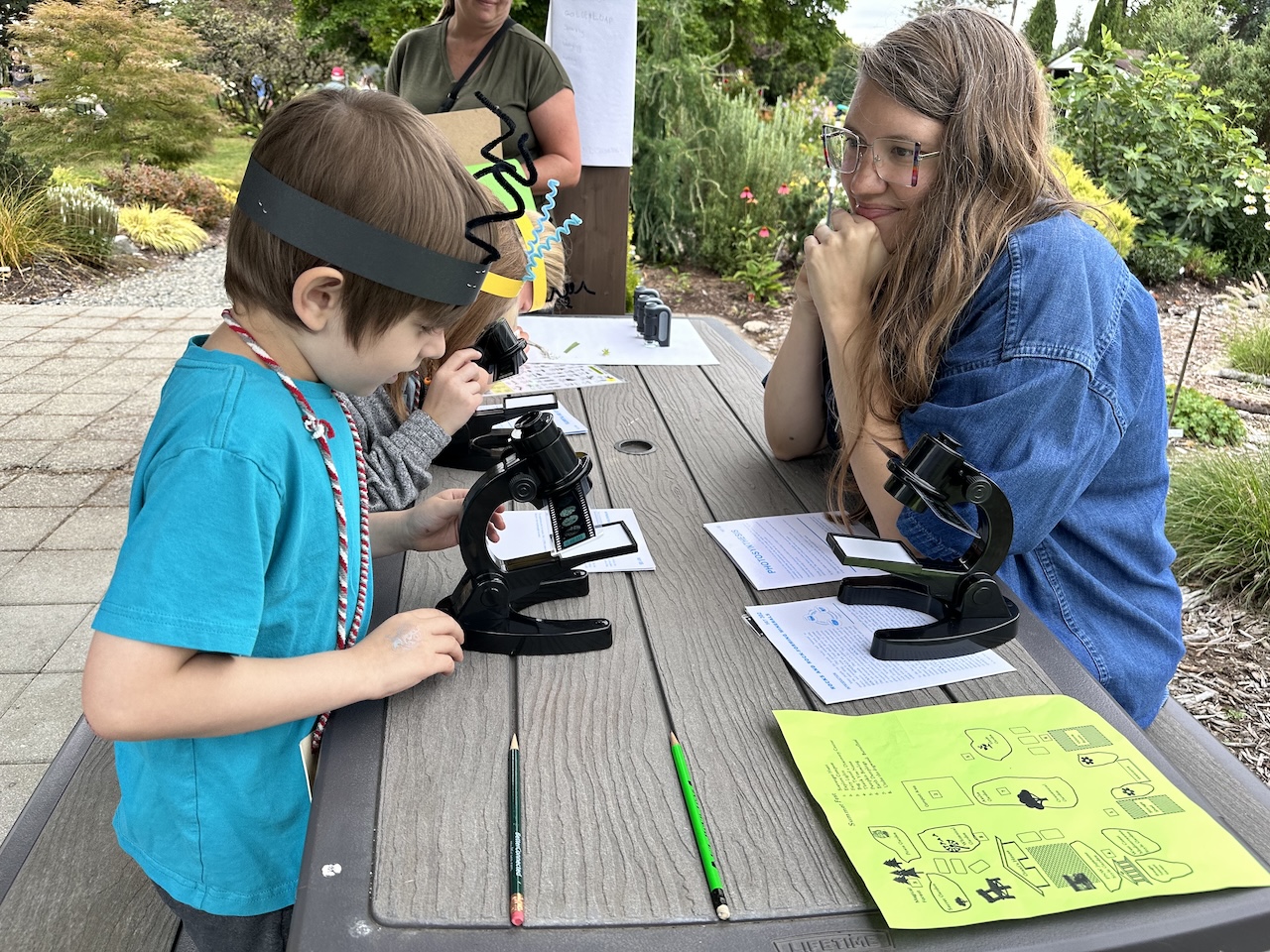 Mom watching son at microscope