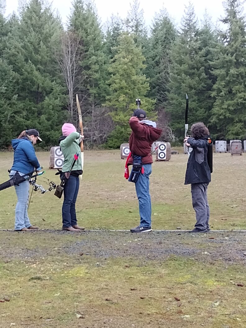 Youth members in the archery project shooting with their bow/arrows