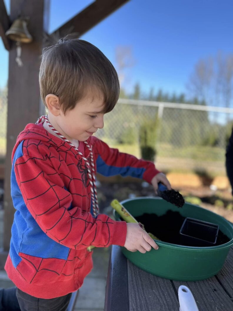 Youth shoveling soil in container