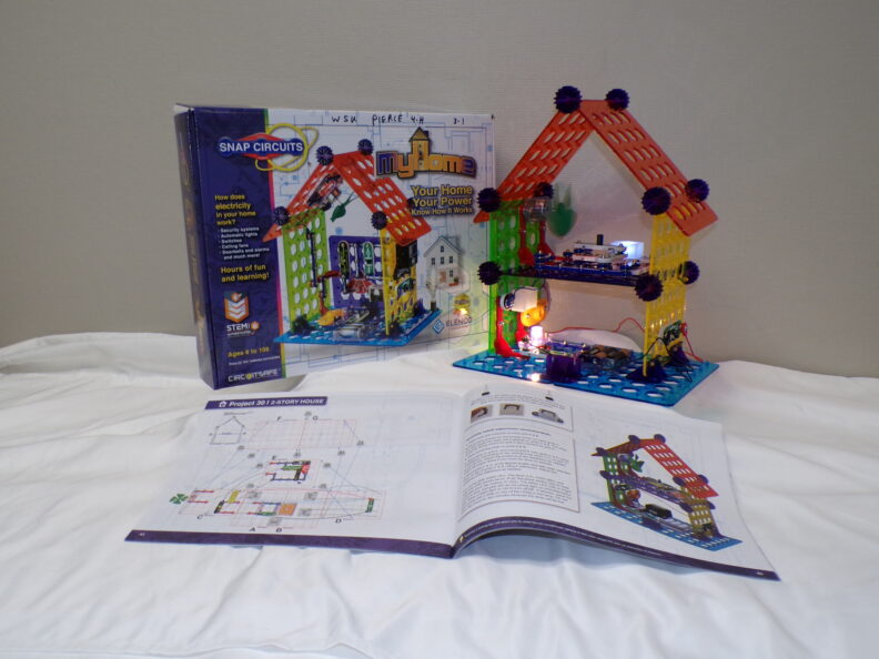 Picture containing a house electrical project, lesson book and STEM kit box