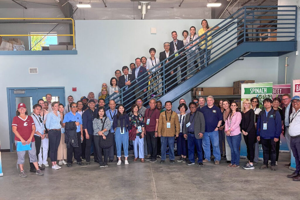 A large group of people standing on stairs in a warehouse.