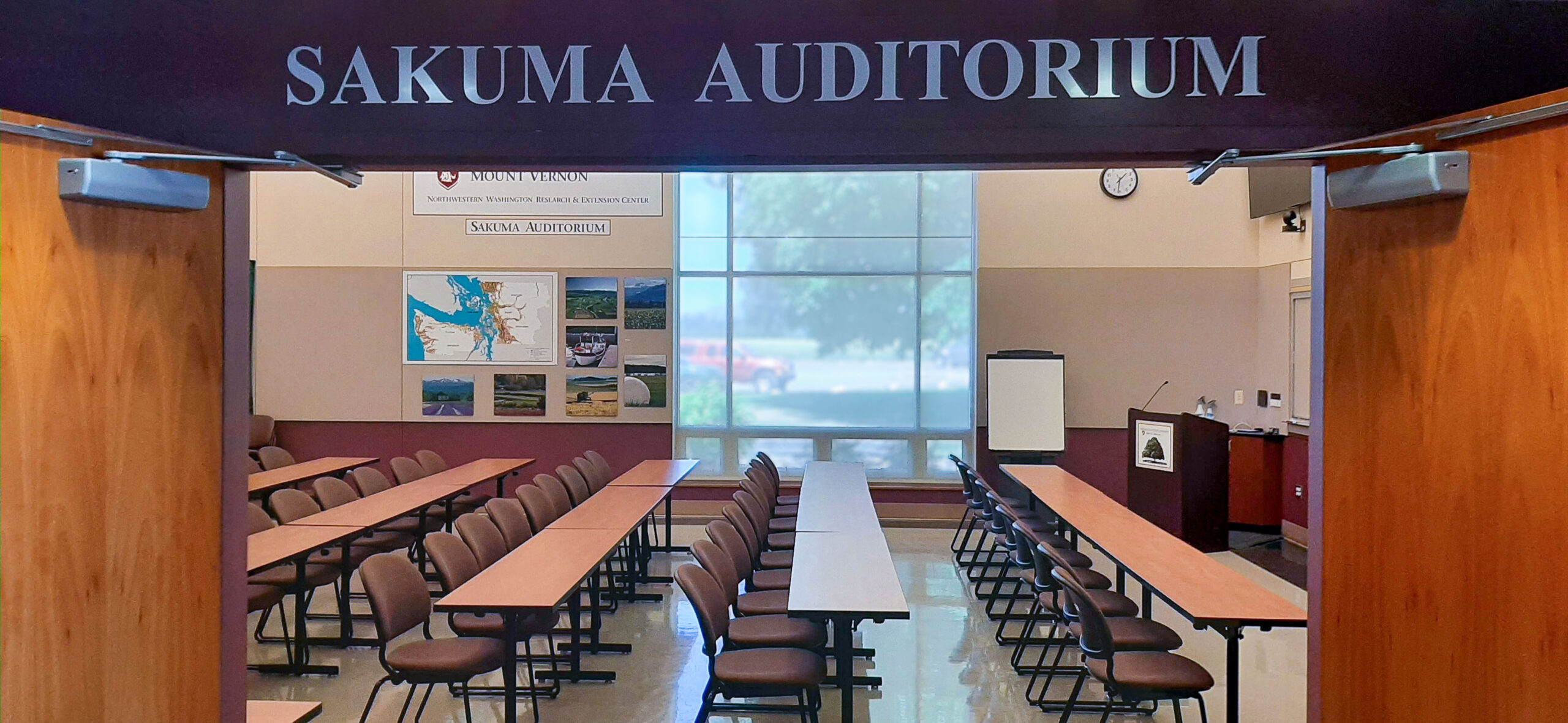 Rows of tables and chairs viewed through an open double door.