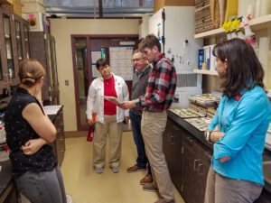 A man and woman look at a sheet of paper in a lab.