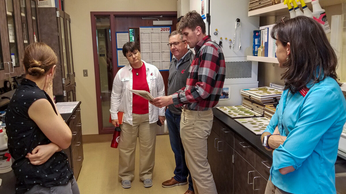 A man and woman look at a sheet of paper in a lab.