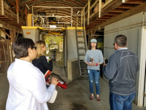 Small group of people standing in front of a large machine.