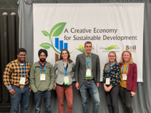 Six people stand in front of a banner reading "A Creative Economy for Sustainable Development"
