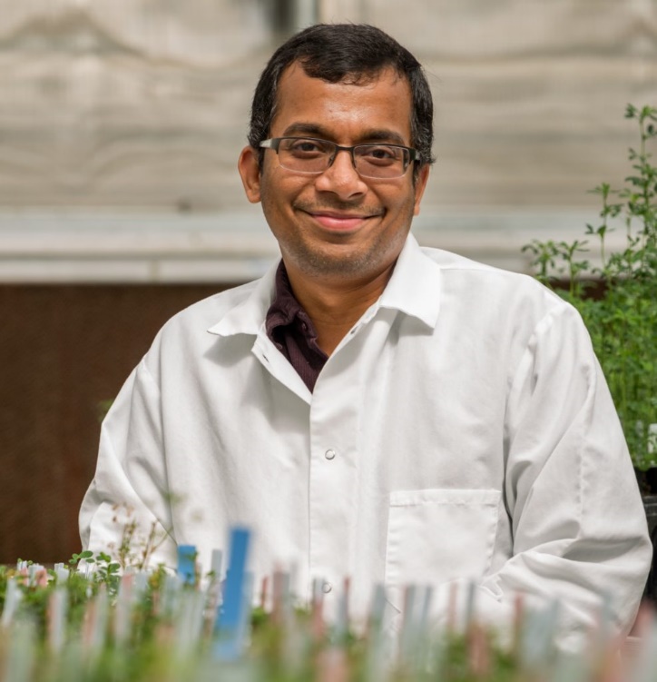 Smiling man wearing a lab coat.