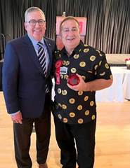 Two men pose with an award.