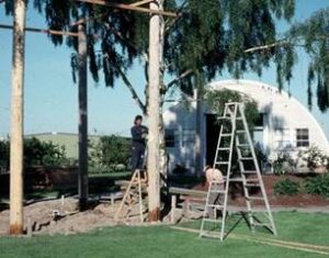 Man on a ladder working on a large post.