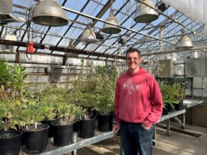 Man standing by potted plants.