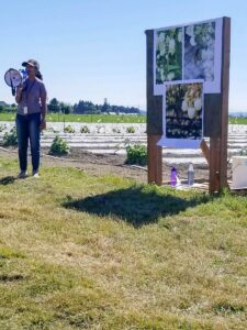 Abigail Attavar presenting with a megaphone in a field.