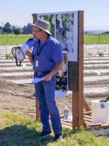 Paul Morgan presenting with a megaphone in a field.