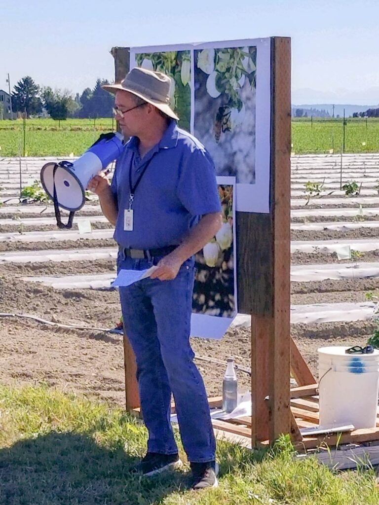 Paul Morgan presenting with a megaphone in a field.