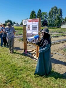 Nadia Bostan presenting with a megaphone in a field.