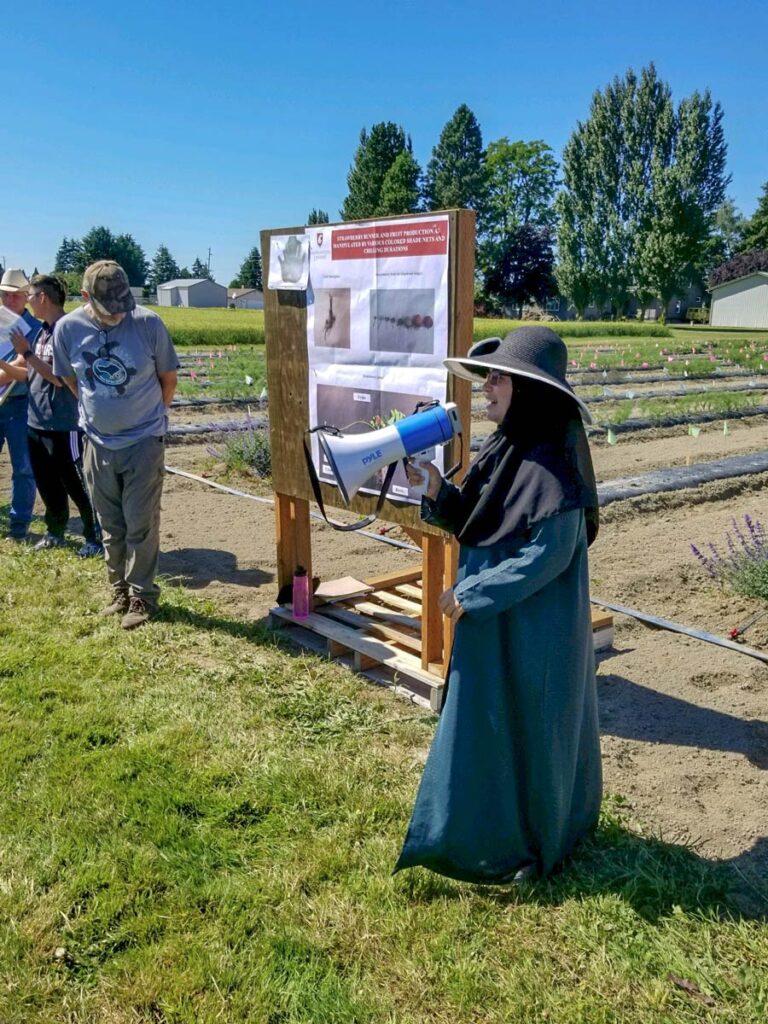 Nadia Bostan presenting with a megaphone in a field.