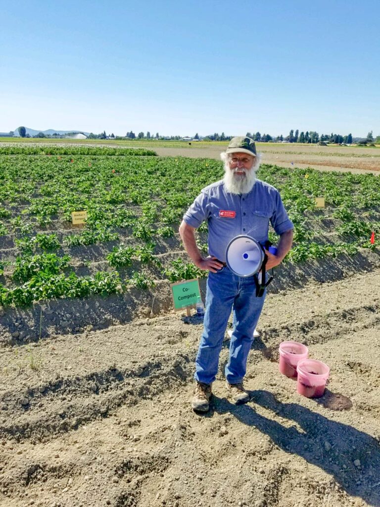 Steven Seefeldt holding a megaphone in a field.