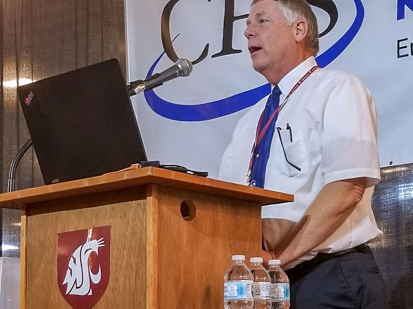Dr. Tim Miller speaking at a podium.