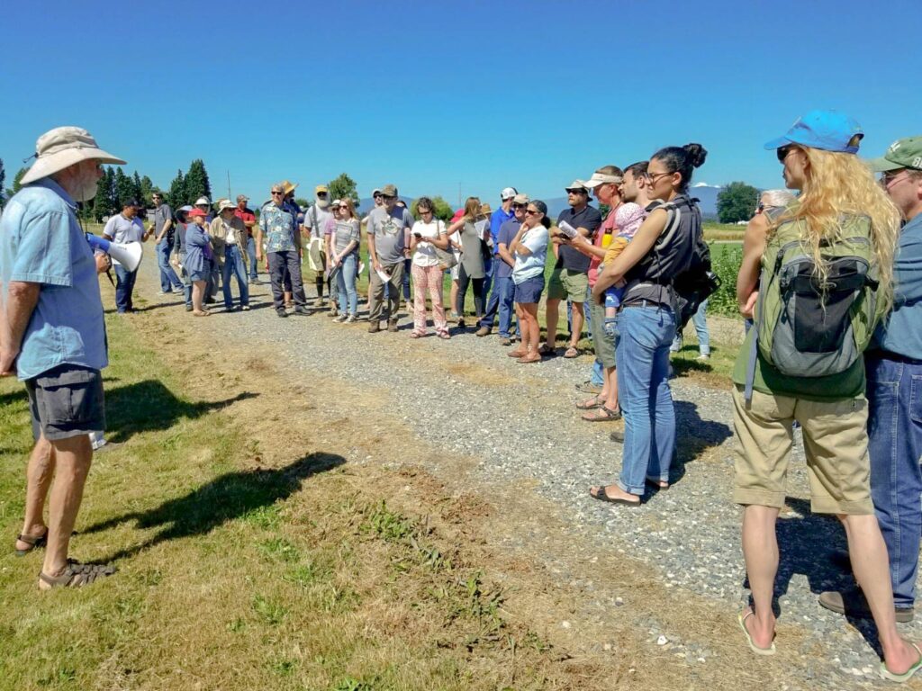 A group of attendees listen to a presentation during the annual NWREC Field Day.