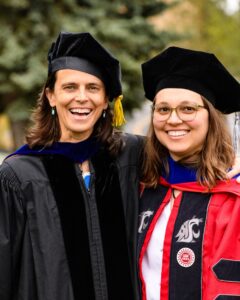 Two women in graduation regalia.