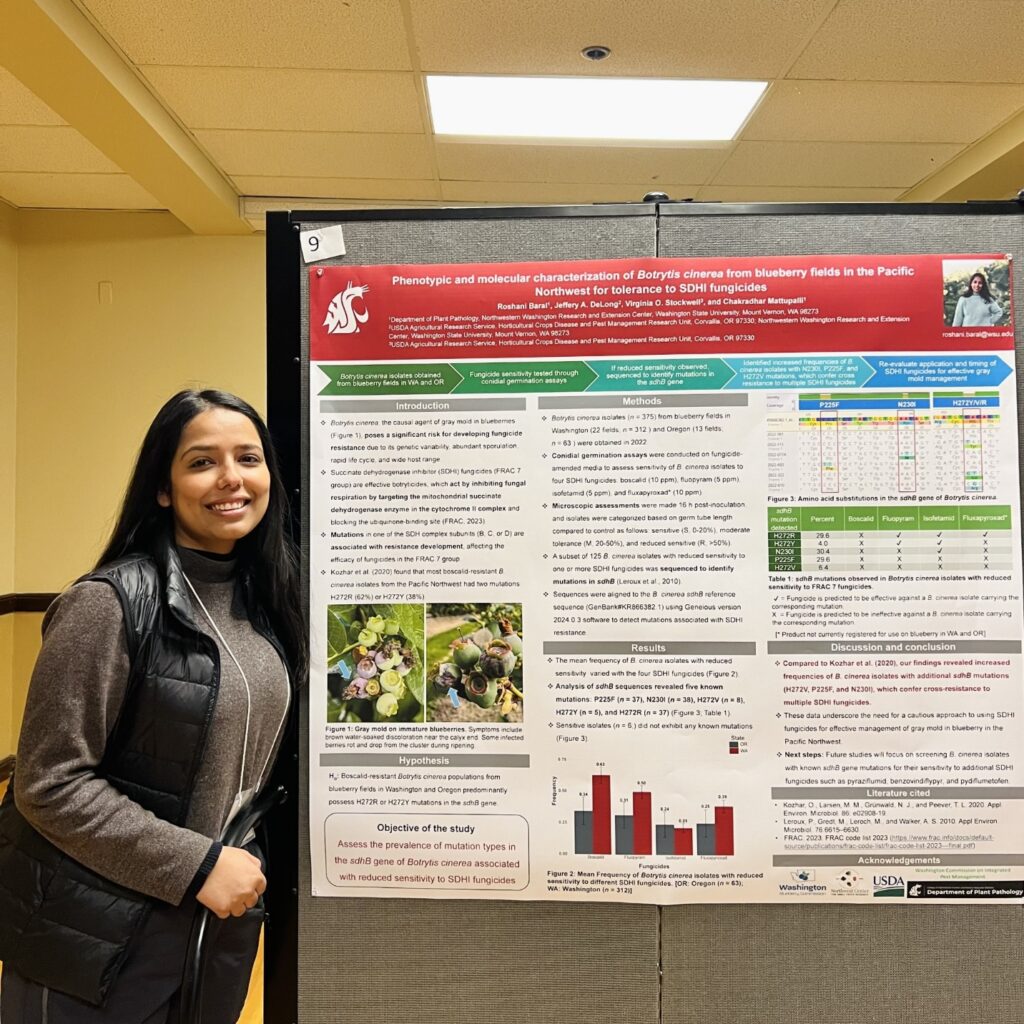 A woman standing next to a research poster.